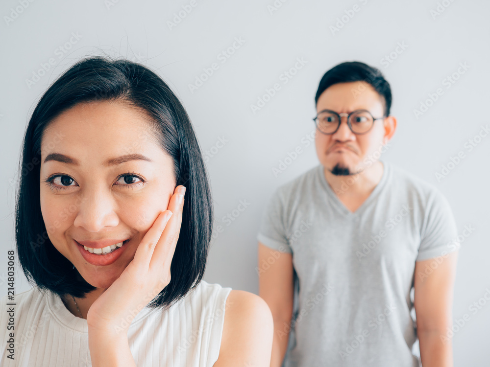 Happy Asian wife and angry loser husband. Happy Asian wife and angry loser husband.