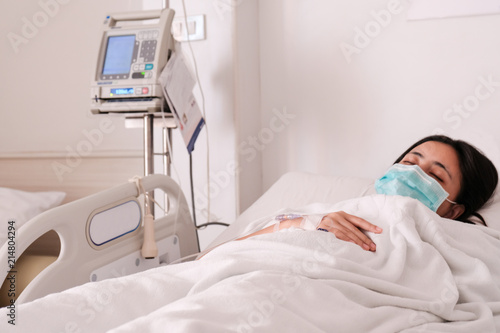 Close up young woman patient lay on bed in hospital with intravenous normal saline