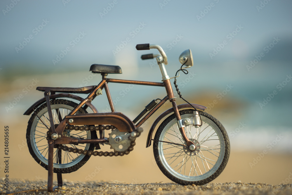 bicycle transport toy on sand sea beach in the evening sunset sky bicycle transport toy on sand sea beach in the evening sunset sky