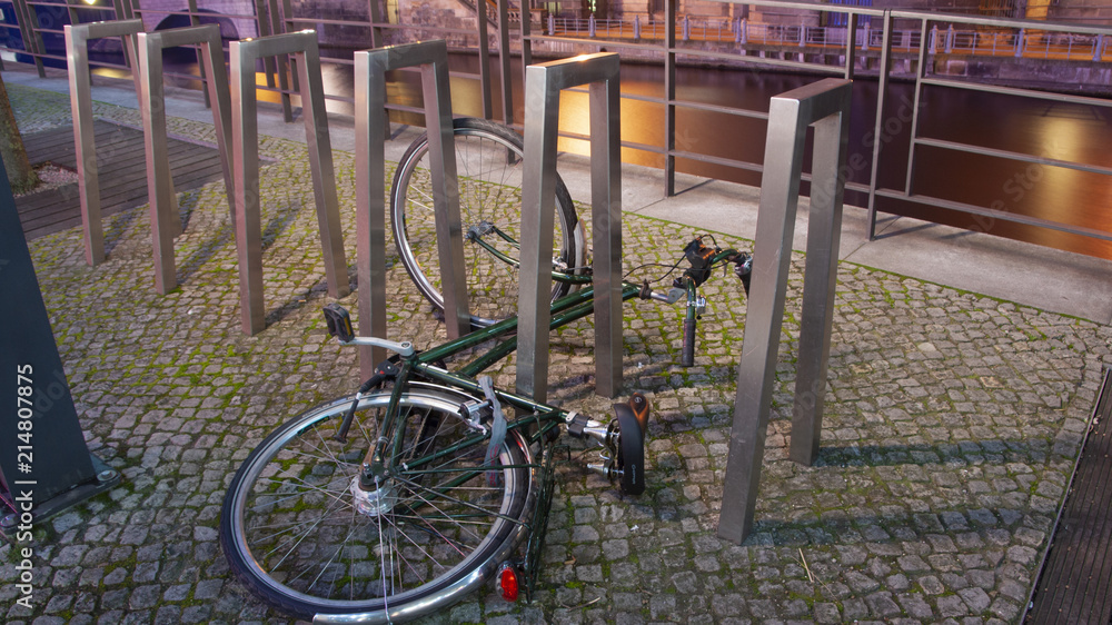 Bicycle resting along a city canal at night, in Berlin, Germany. Bicycle resting along a city canal at night, in Berlin, Germany.