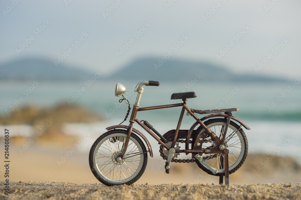 bicycle transport toy on sand sea beach in the evening sunset sky bicycle transport toy on sand sea beach in the evening sunset sky