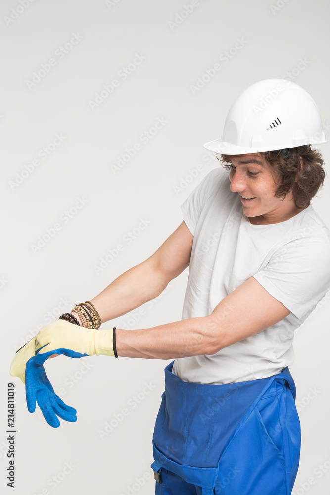 portrait of happy builder in helmet wearing glove. portrait of happy builder in helmet wearing glove.