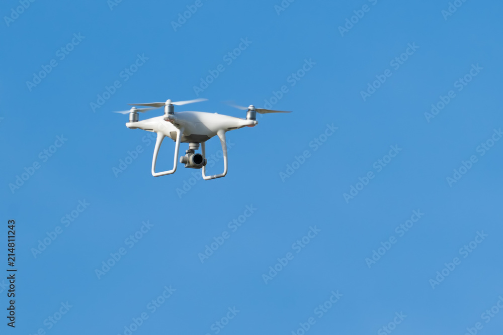 Drone quadcopter with digital camera, Drone hovering in blue sky Drone quadcopter with digital camera, Drone hovering in blue sky