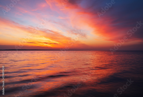 Beautiful spring landscape with sea coast, colorful sunset sky. © es0lex