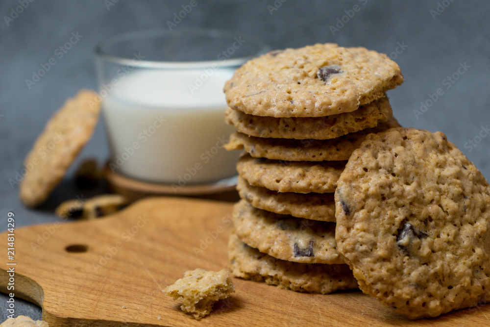 Oatmeal cookies and milk on a wooden board and gray background Oatmeal cookies and milk on a wooden board and gray background