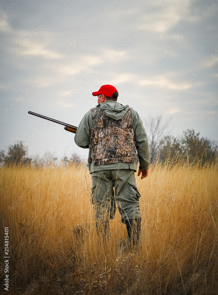 Hunter moving with shotgun looking for prey. Hunting for hare Hunter moving with shotgun looking for prey. Hunting for hare
