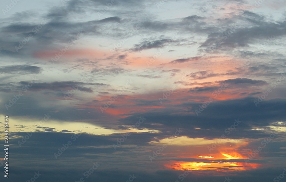 Beautiful colorful sunset with black dramatic clouds in the sky, natural background