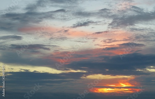 Beautiful colorful sunset with black dramatic clouds in the sky, natural background