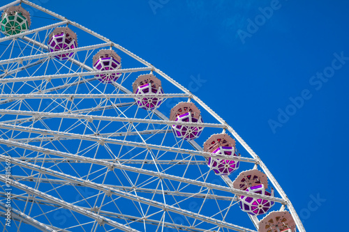 Ferris wheel on blue sky background. In the amusement Park. The weekend