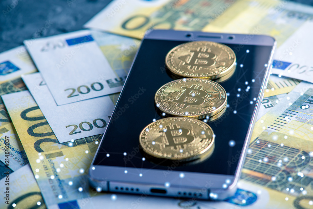 Bitcoin coin on the phone screen on the background of Euro banknotes. Concept of cryptocurrency and blockchain Bitcoin coin on the phone screen on the background of Euro banknotes. Concept of cryptocurrency and blockchain