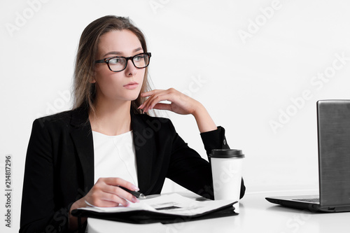 Businessman girl sitting at desk in office and working on laptop on white background. photo