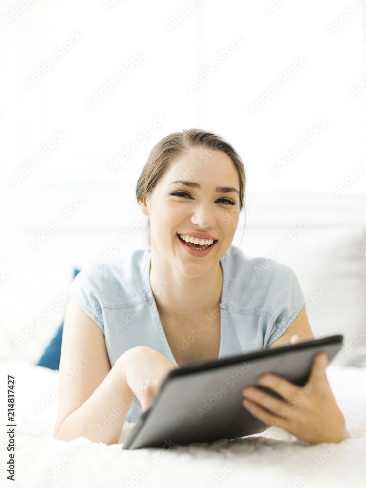 Smiling woman holding folder on bed Smiling woman holding folder on bed