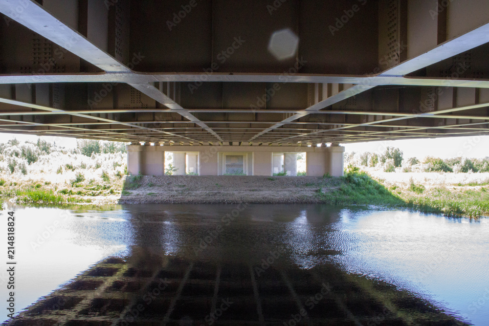 reflection of a bridge in a blue river reflection of a bridge in a blue river