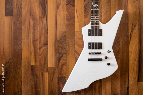 Fotografie Weiße Heavy E-Gitarre auf braunem Hintergrund