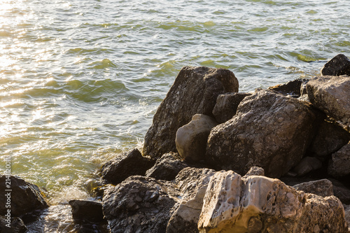 Sea waves are fighting against the big rocks on the shore.