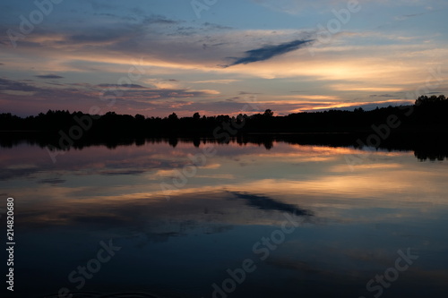 Fiery skies at sunset and light reflections in the lake © Milda