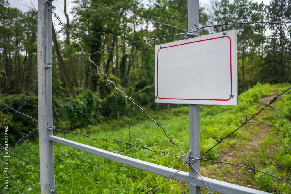 Forbidden area fenced with a barbed wire fence. Gate with padlock closed to the key. Border of States Forbidden area fenced with a barbed wire fence. Gate with padlock closed to the key. Border of States
