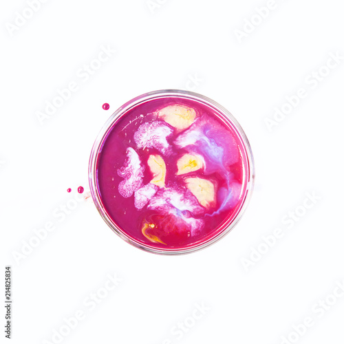 Fluid art in a petri dish. Colorful acrylic, ink, oil and watercolor marble paint splashes. Abstract fluid ocean of color or alien planet of liquid color. Living colorful bacteria in a petri dish.