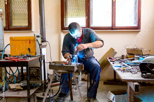Artist is making figure by welding few metal wires in his workshop, barehanded