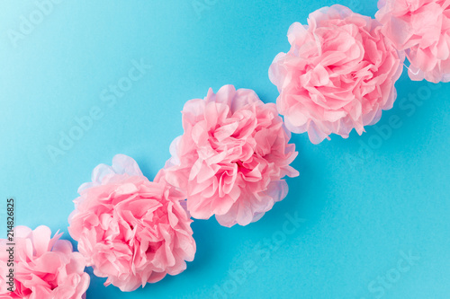 Fototapeta Naklejka Na Ścianę i Meble -  Pink flower pattern on blue pastel background. Minimal spring concept. Flat lay. Top view