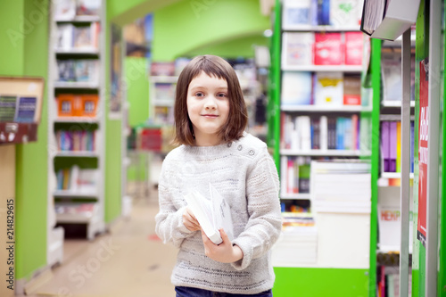 Cute girl reading books at store
