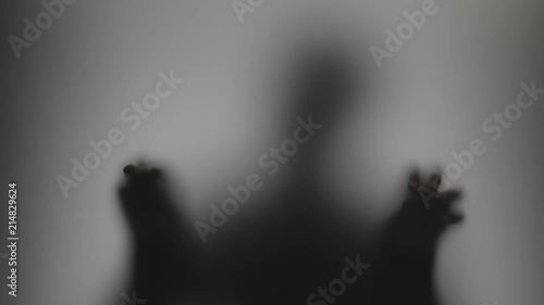 Shadowy figure behind glass / fear, panic concept