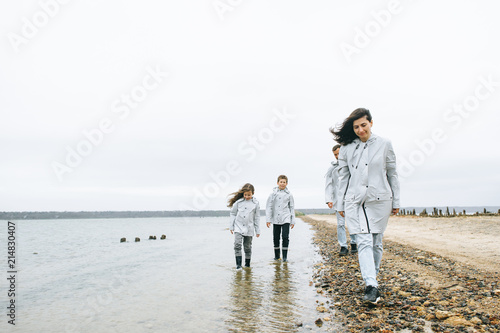 Beautiful family portrait dressed in raincoatnear the sea
