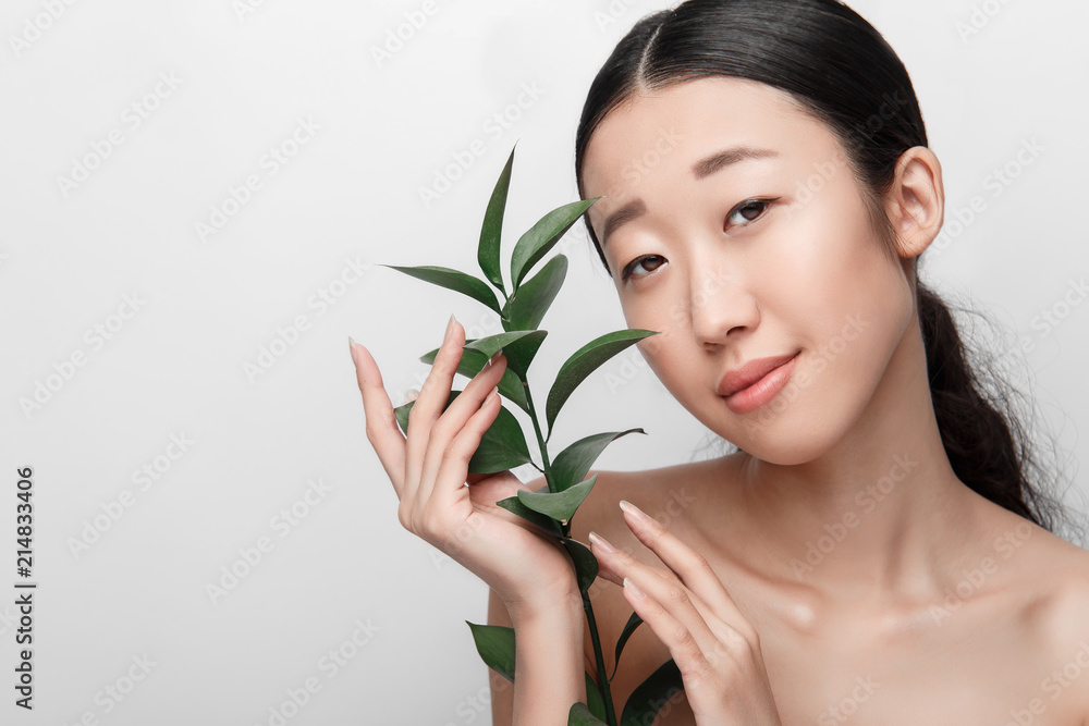 Close up of beauty portrait of beautiful Asian half naked woman with plant, isolated on white background Close up of beauty portrait of beautiful Asian half naked woman with plant, isolated on white background