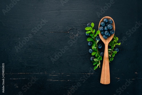 Fresh blueberry in a wooden spoon. On a wooden table. Top view. Free space for your text.