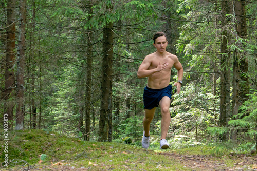 The athlete commits a morning run through the forest