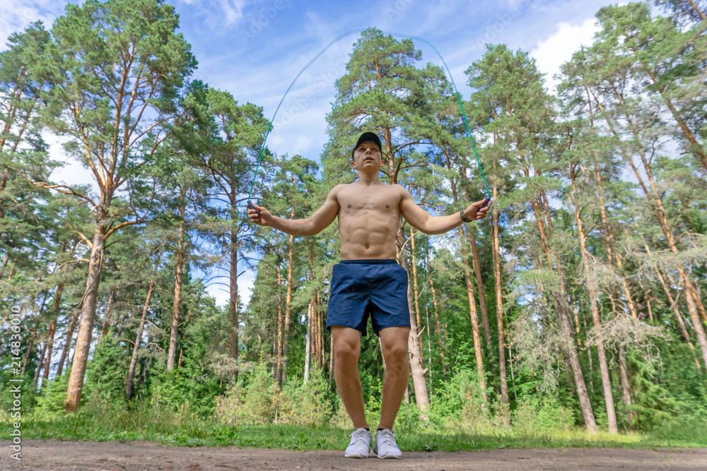 Young man jumping rope in the park
