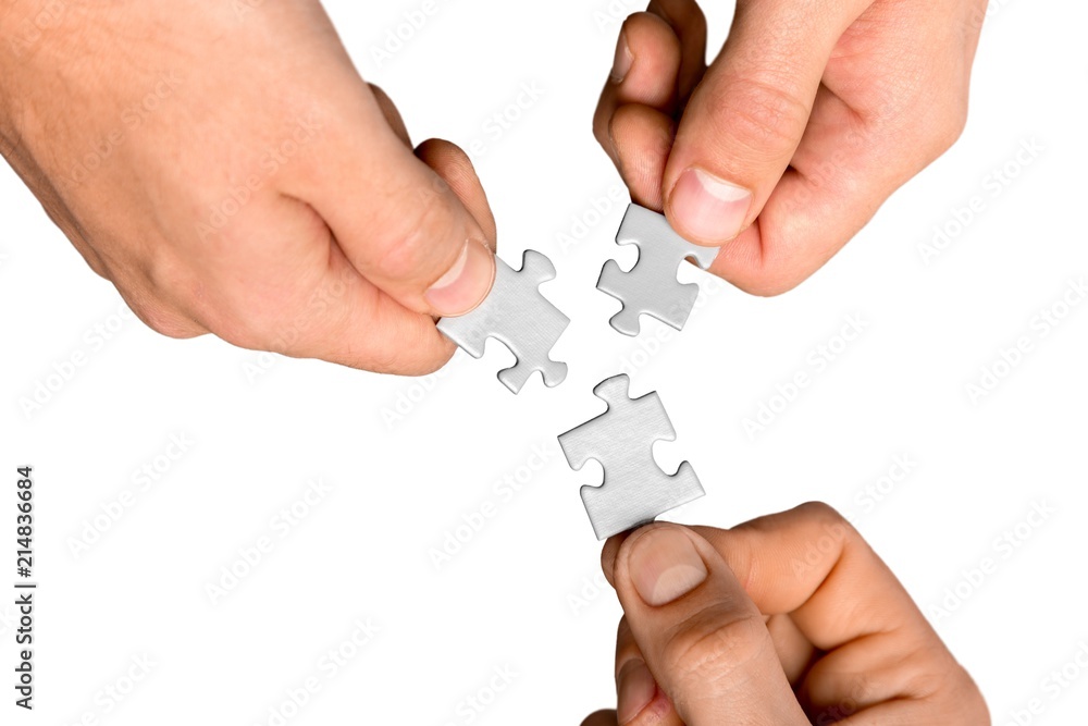 Closeup on Hands Combining Puzzle Pieces Together