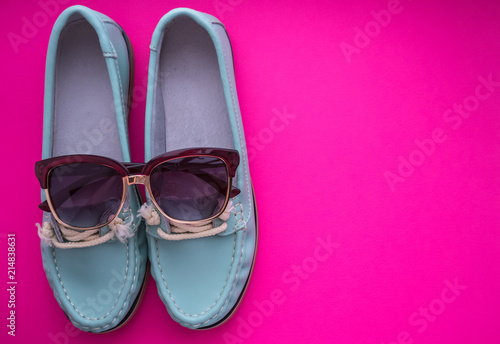 blue moccasins with glasses on magenta background