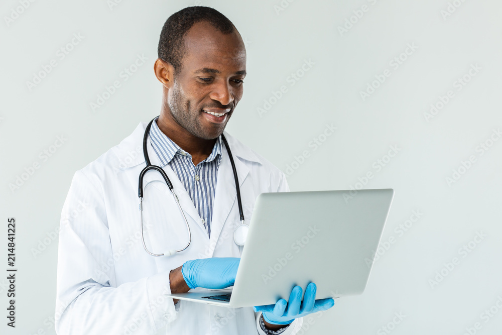 Professional afro american doctor using his laptop Professional afro american doctor using his laptop