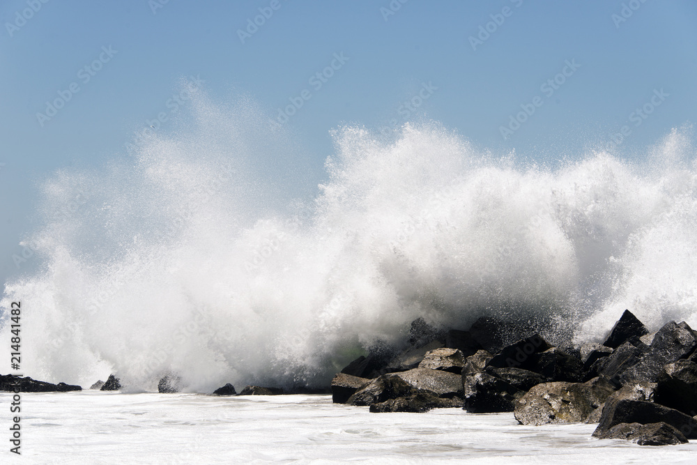 Obraz premium An extreme high wave crashing to rocks in the beach of Venice, California in summertime