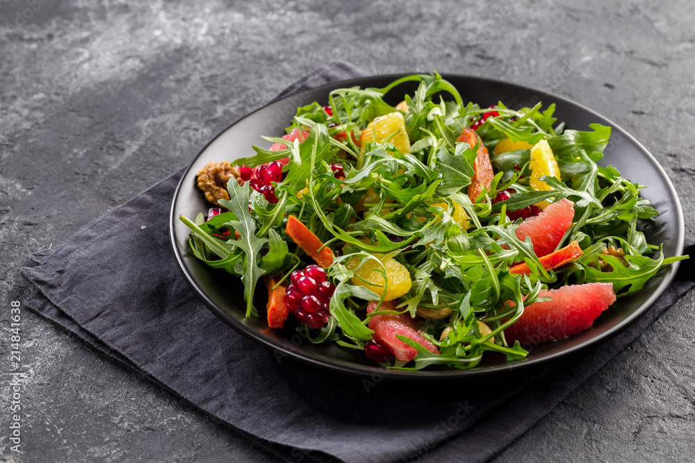 Fruit salad on black plate on dark background