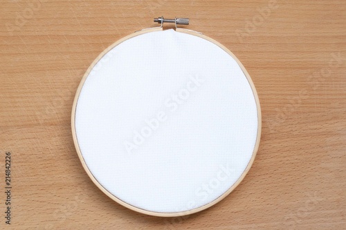 Round wooden hoop with a white cloth.