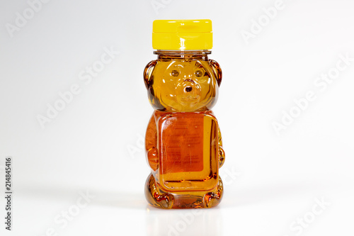 A bear shaped plastic bottle full of honey waiting to be used 