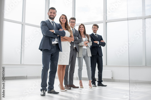 group of businessmen and businesswoman standing in an office with a large window