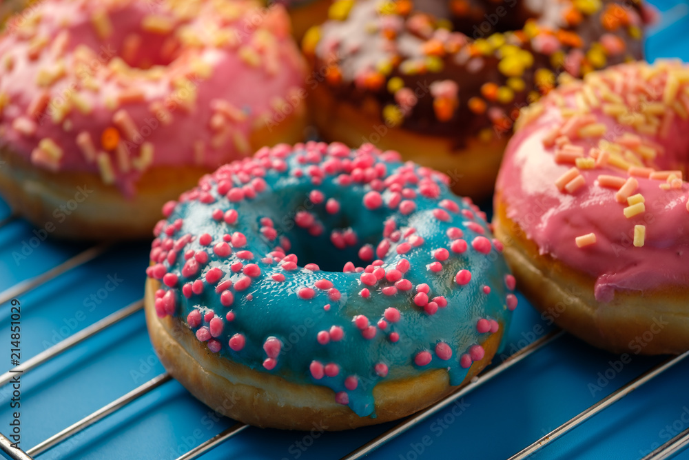 Variety of colorful tasty glazed donuts on a colored background