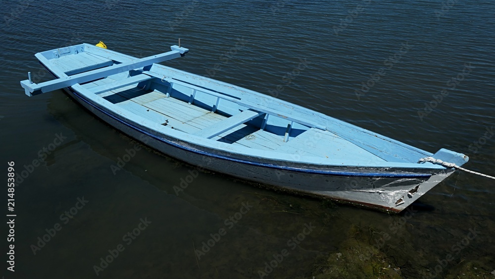 Slim light blue fishing boat with vertical oar support Slim light blue fishing boat with vertical oar support