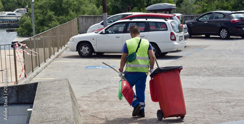 Ein Mann räumt den Müll auf einem Parkplatz zusammen  © Richtsteiger