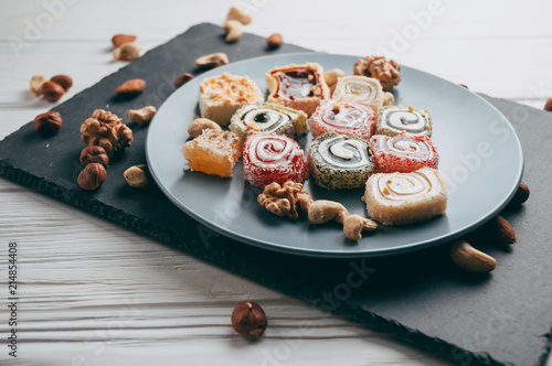 Bilde på lerret Traditional oriental sweets and nuts: hazelnuts, cashews on a white wooden background