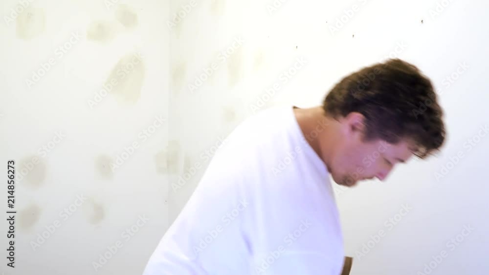 Painting worker puttied wall using a paint spatula hand worker repairs gypsum plasterboard Painting worker puttied wall using a paint spatula hand worker repairs gypsum plasterboard