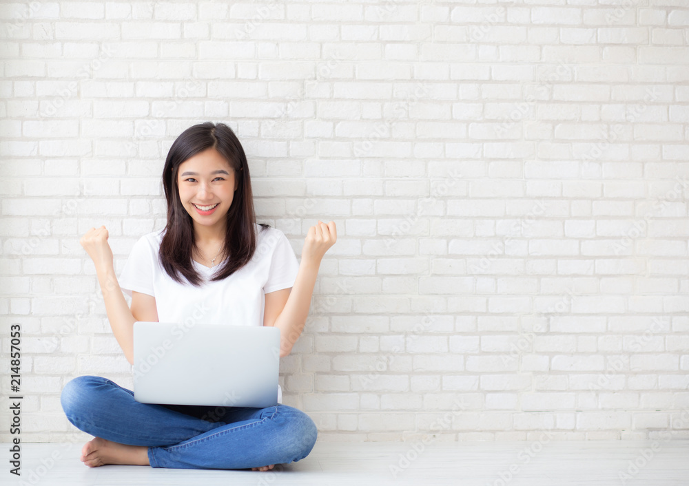Beautiful of portrait asian young woman excited and glad of success with laptop computer, girl sitting working on cement brick background, career freelance business concept. Beautiful of portrait asian young woman excited and glad of success with laptop computer, girl sitting working on cement brick background, career freelance business concept.
