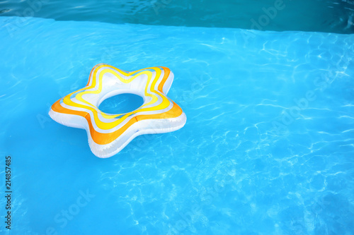Inflatable ring floating in swimming pool on sunny day