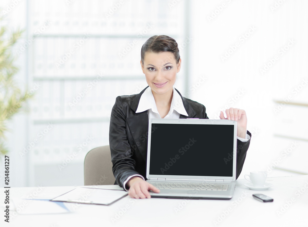 Executive business woman showing a laptop sitting at her Desk Executive business woman showing a laptop sitting at her Desk