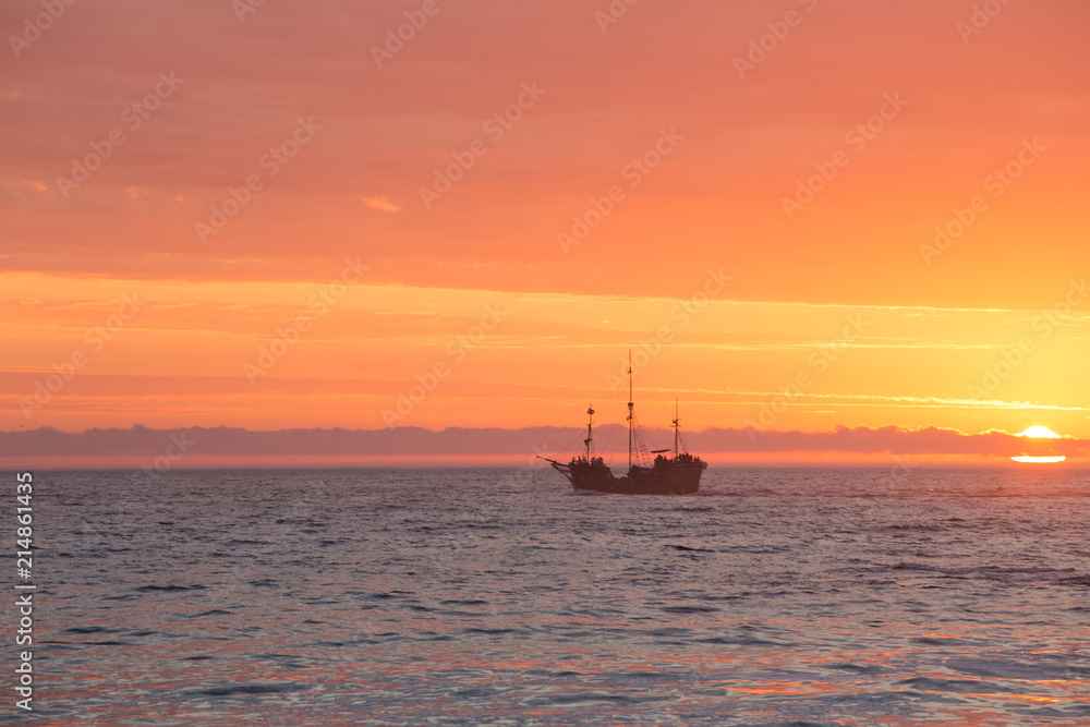 Scenic image of a tall ship sailing off into the sunset in Cape Town South Africa