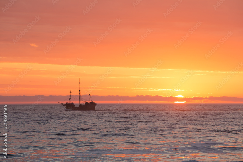 Scenic image of a tall ship sailing off into the sunset in Cape Town South Africa