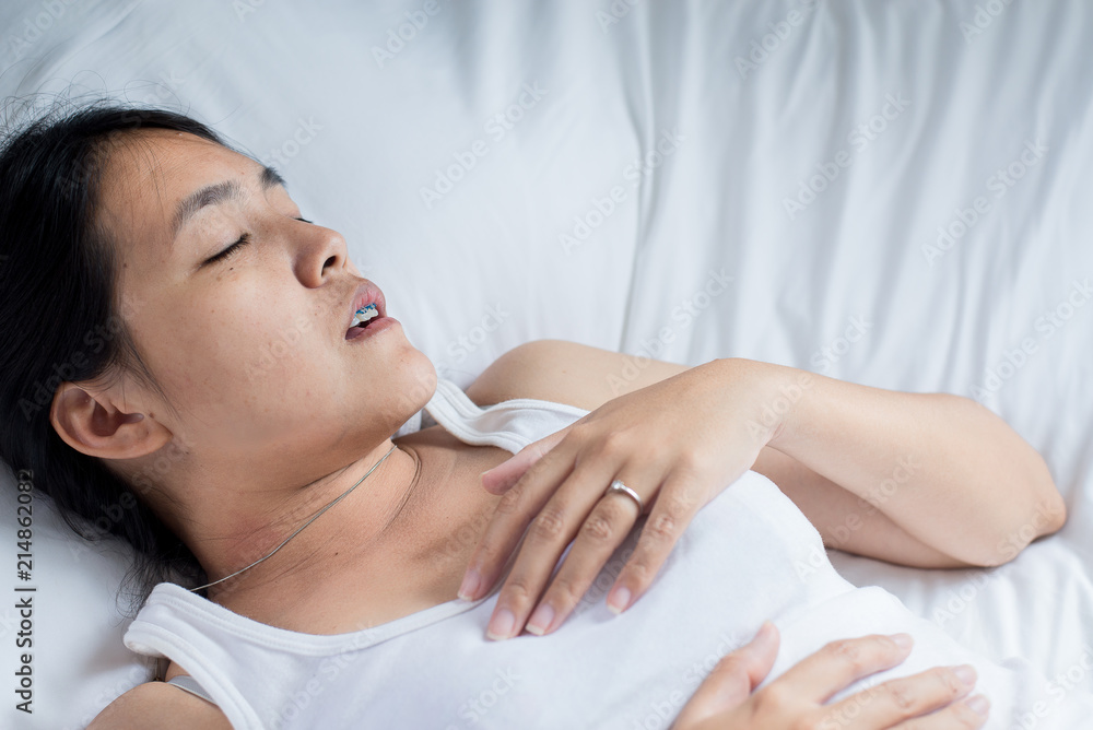 Asian woman snoring because due to tired of work,Female snor while sleeping on bed Asian woman snoring because due to tired of work,Female snor while sleeping on bed